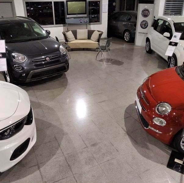 Una sala de exposición llena de coches y un sofá.