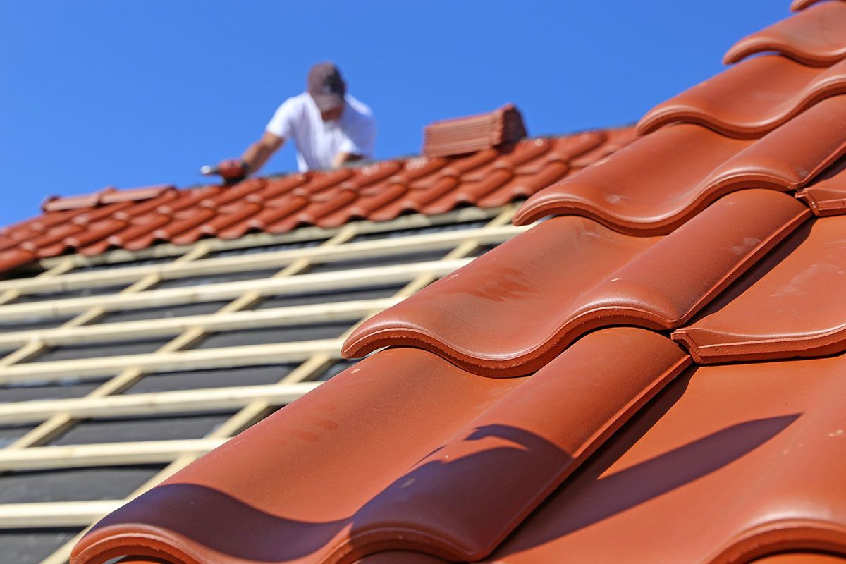 Homme sur une toiture qui fait des travaux