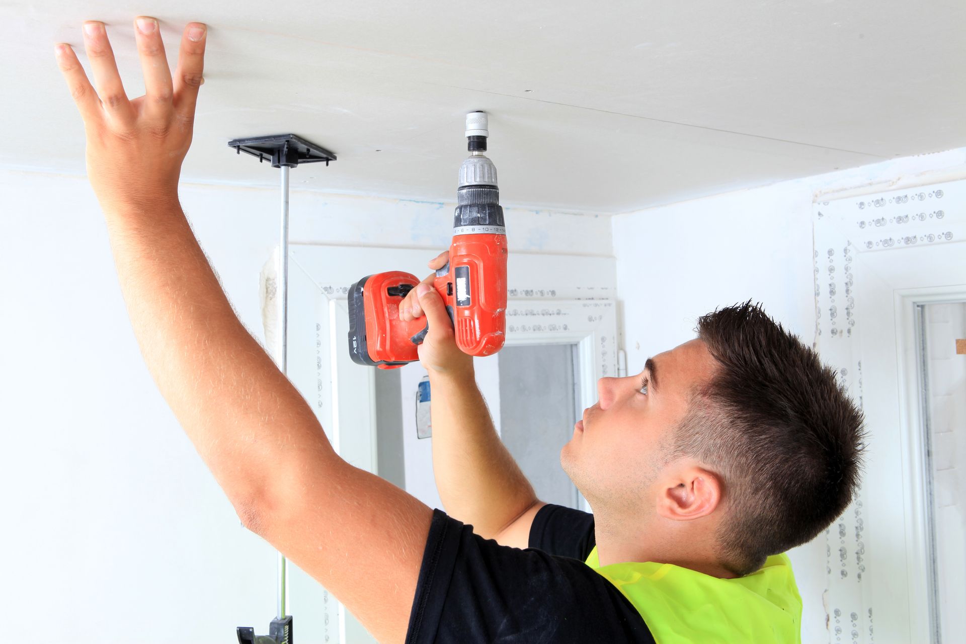 Homme qui pose un faux plafond