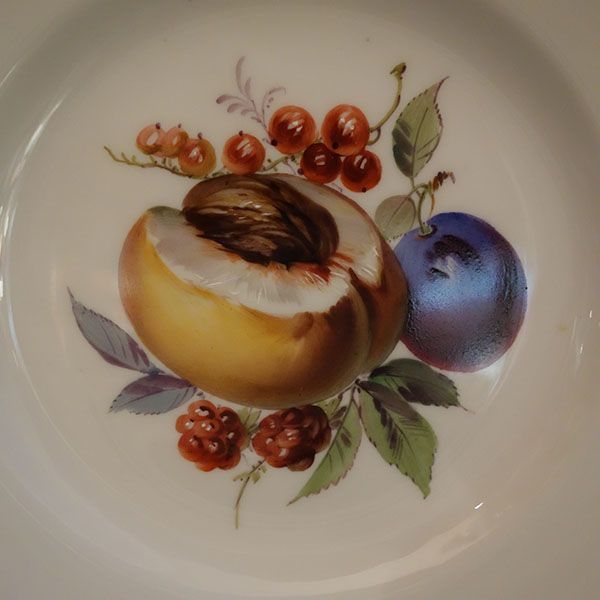 Weißer Teller mit einem gemalten Arrangement aus Pfirsich, Pflaume, Himbeeren und roten Johannisbeeren.