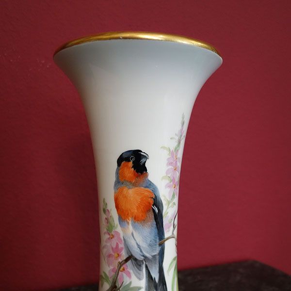 Weiße Porzellanvase mit einem handgemalten Vogel auf einem Blumenzweig, Goldrand.