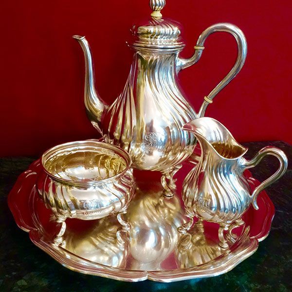 Silbernes Teeservice auf einem Tablett, bestehend aus Teekanne, ein Milchkännchen und eine Zuckerdose.