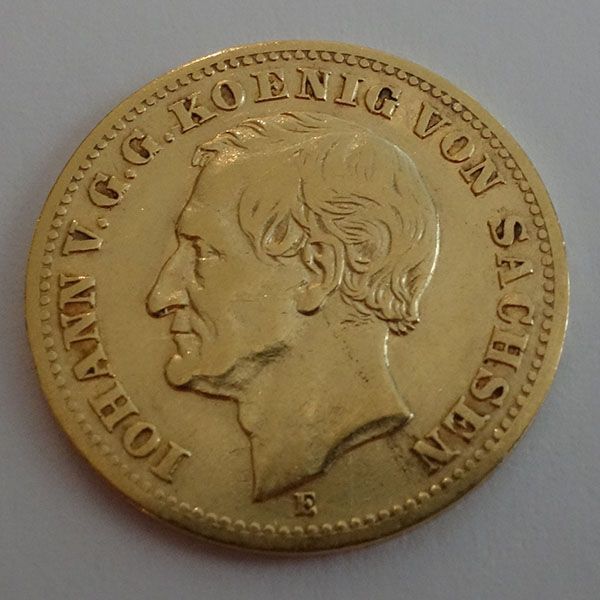 Goldmünze mit Kopf im Profil und Text.