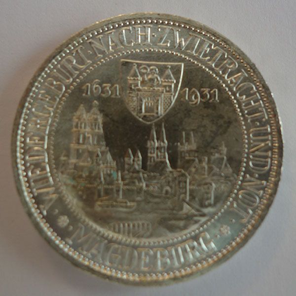 Silbermünze zur Erinnerung an Magdeburg mit Stadtsilhouette und Inschrift.