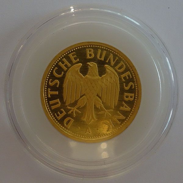 Goldmünze mit Adler und dem Text „DEUTSCHE BUNDESBANK“ in einem durchsichtigen Kunststoffetui.