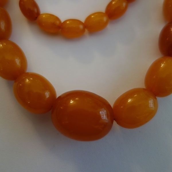 Bernsteinperlenkette, ovale Perlen, verschiedene Größen, gold-orange Farbe.