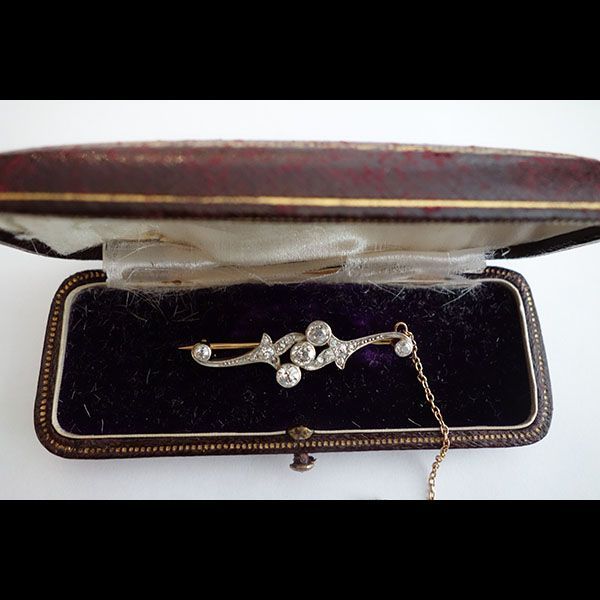 Diamant- und Goldbrosche in antiker Schmuckschatulle mit violettem Futter und Kette.