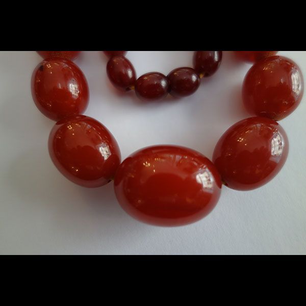 Rote Perlenkette auf weißem Hintergrund.