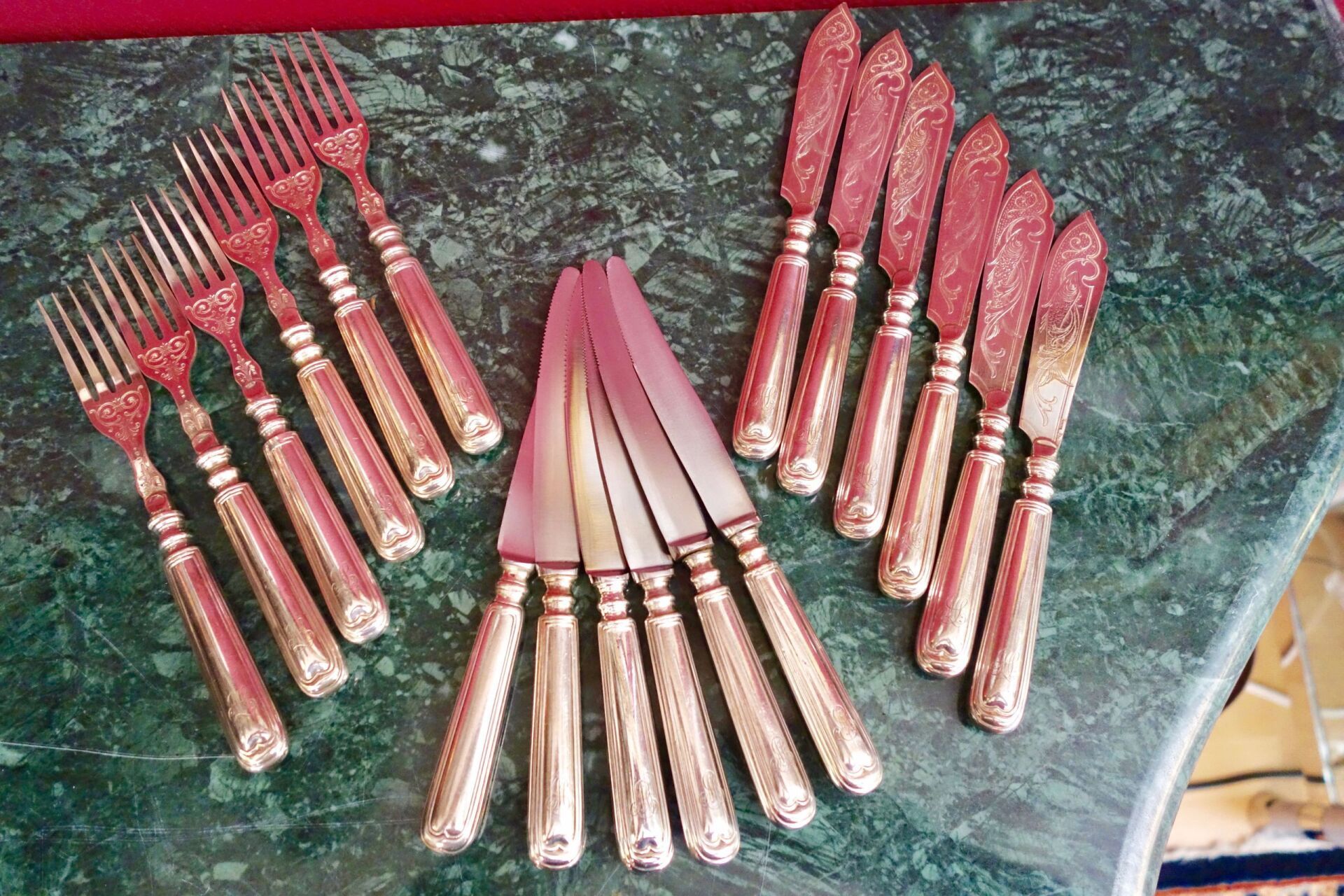 Besteckset: Gabeln, Messer und Aufstriche auf einer marmorierten Oberfläche.