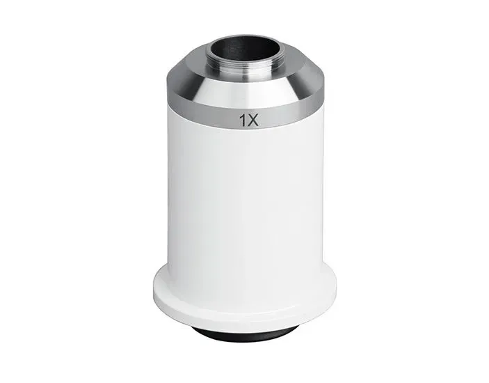 Objetivo de microscopio blanco con borde plateado, etiquetado “1X”.