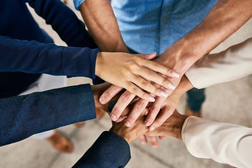 Un grupo de personas junta sus manos.