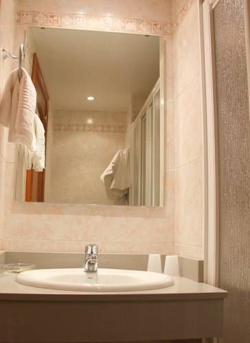 Un baño con lavabo, espejo y cabina de ducha.