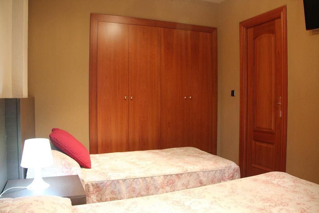 Un dormitorio con dos camas y un amplio armario.