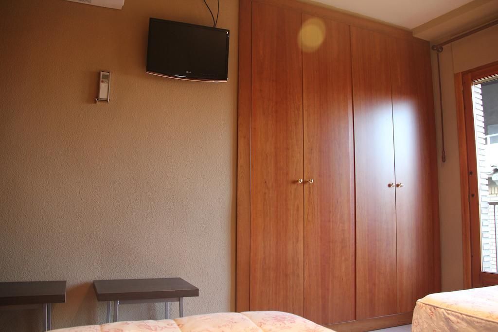 Un dormitorio con dos camas y un televisor de pantalla plana.