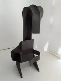 Una escultura negra está sentada encima de una mesa blanca.