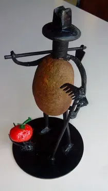 Una estatua de un hombre hecha de patatas y tomates.