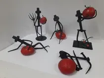 Un grupo de esculturas de tomates colocadas encima de una mesa.