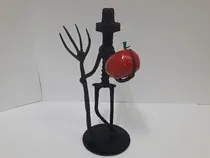 Un candelabro con un tenedor y una manzana encima.
