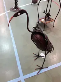 Un pájaro hecho con una pelota de baloncesto está parado en una cancha de baloncesto.