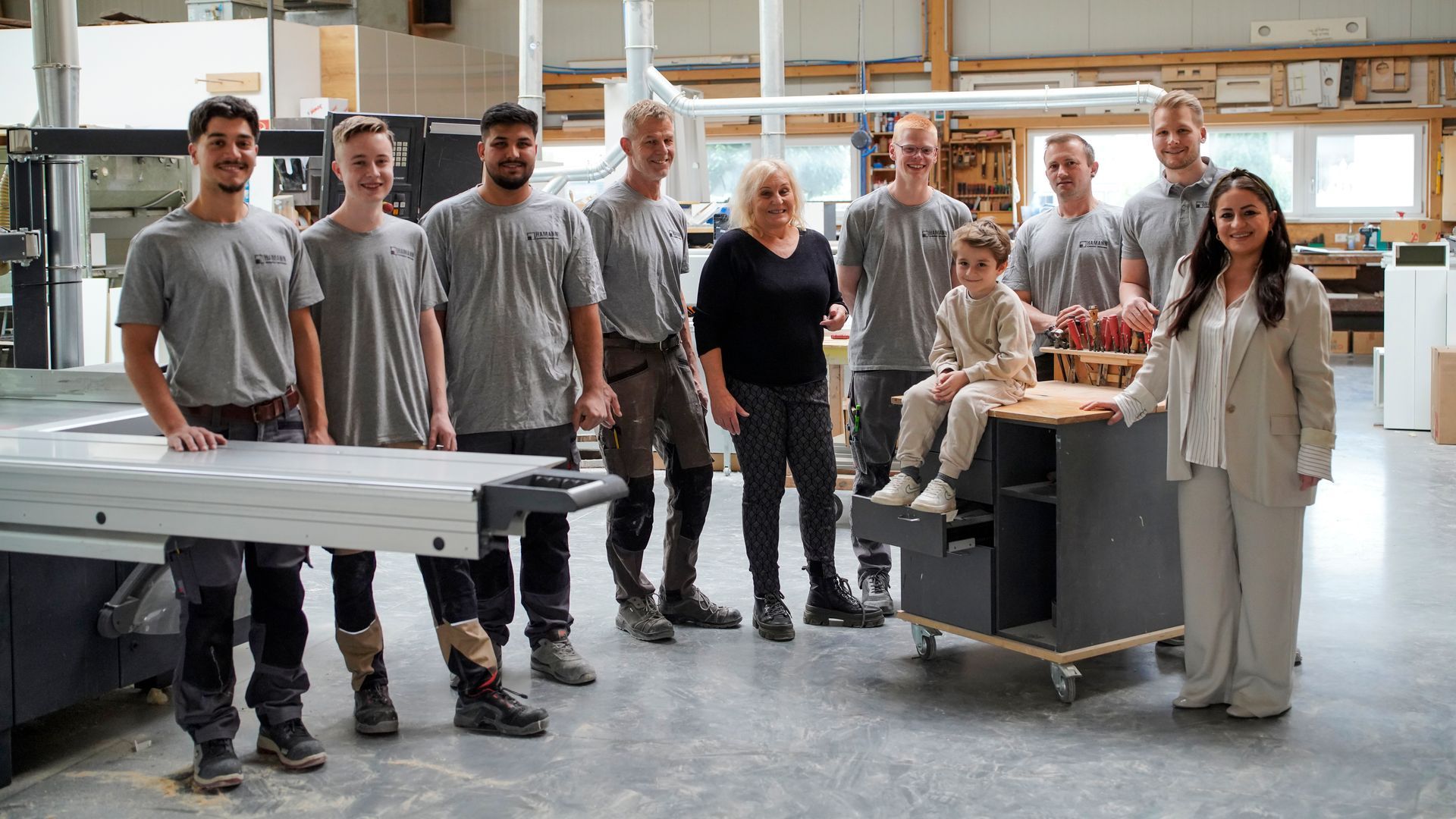 Eine Gruppe von Menschen posiert in einer Fabrik für ein Foto.