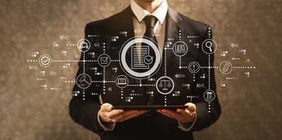 Hombre de negocios sosteniendo una tableta con iconos de tecnología digital brillantes a su alrededor.