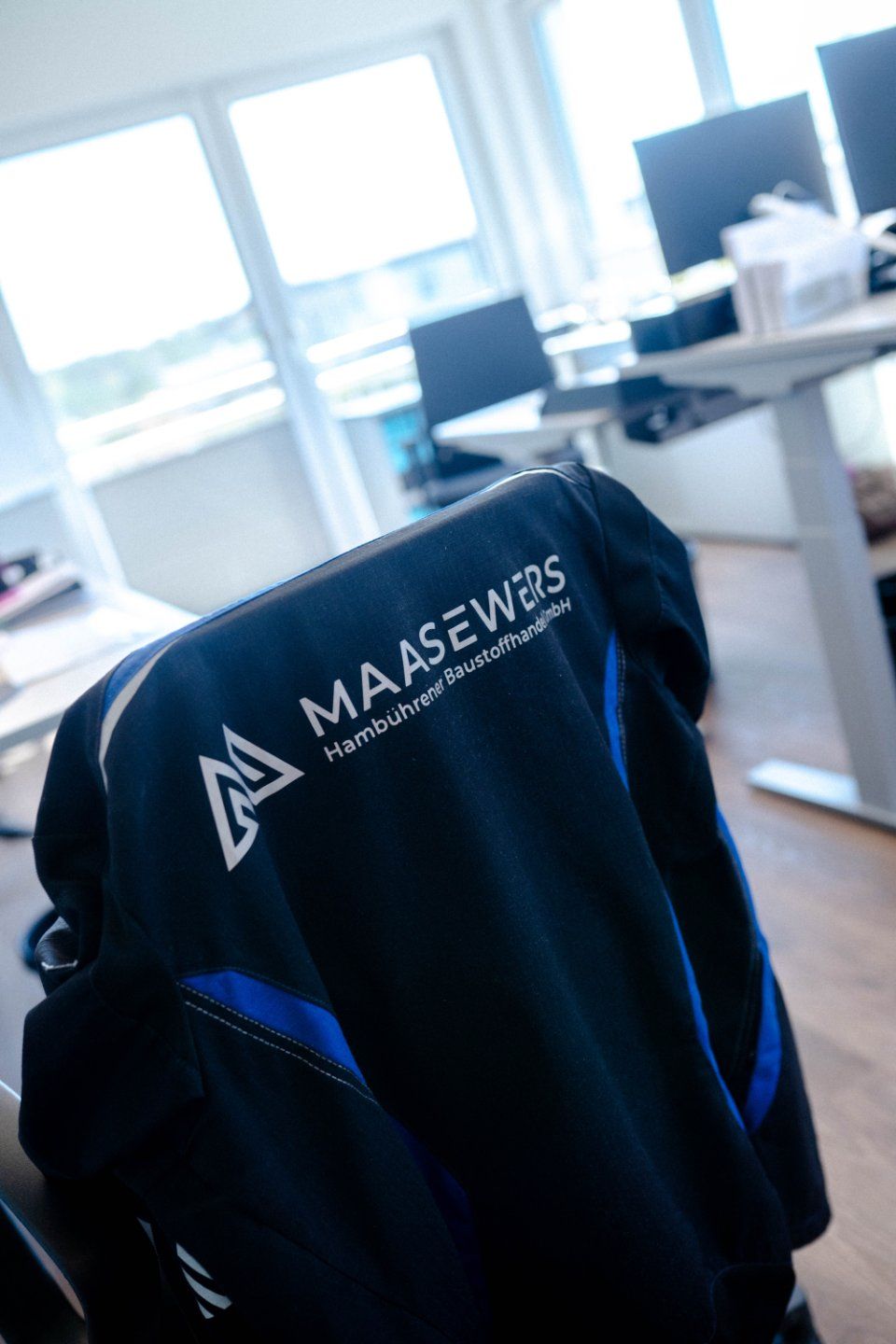 Gelbe Sicherheitsweste und schwarze Jacke mit aufgehängtem „Maasewers“-Logo.