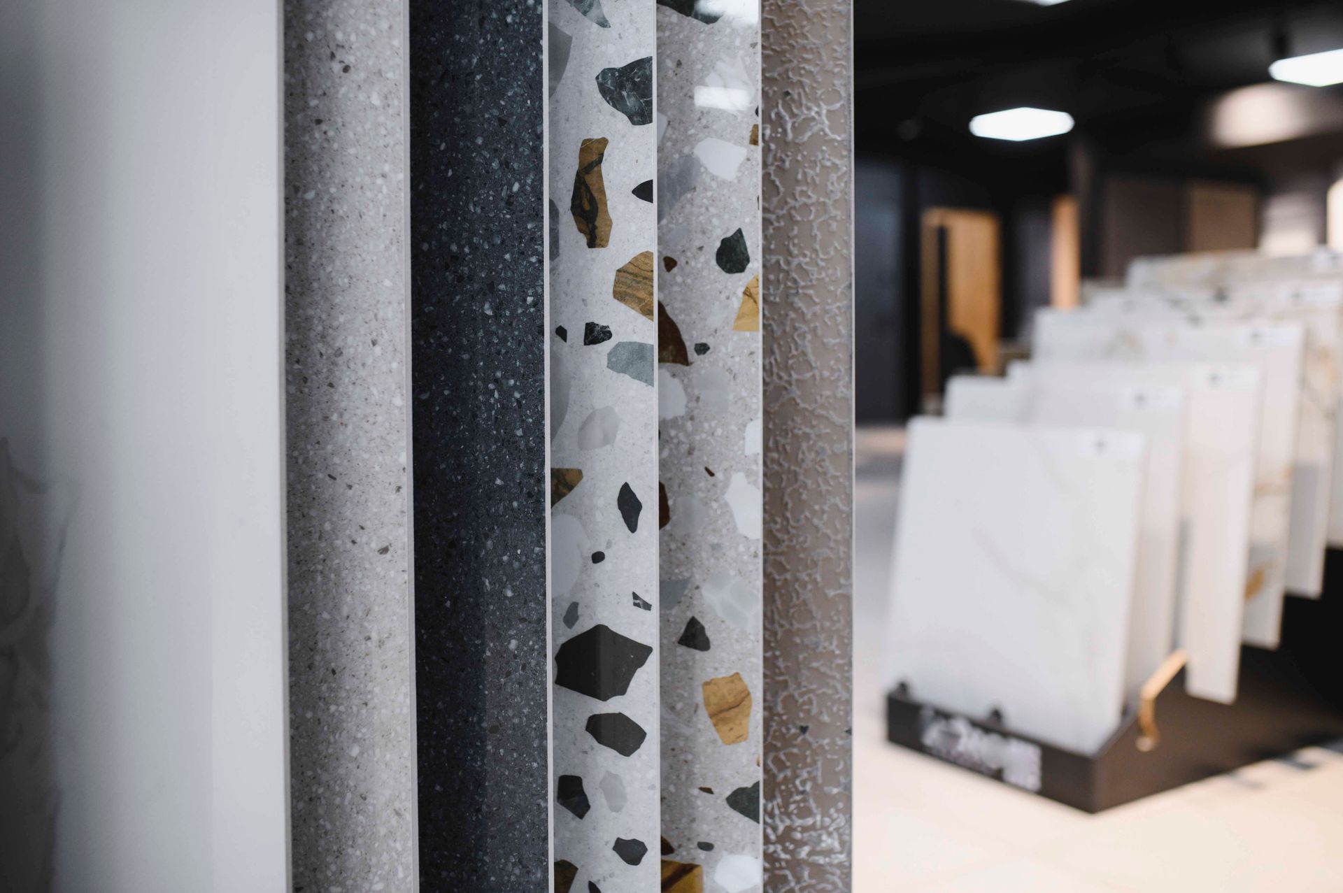 Eine Ausstellungsfläche mit verschiedenen Stein- und Terrazzo-Oberflächenmustern in unterschiedlichen Farben und Mustern.
