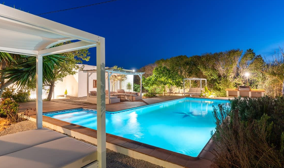 Get to know Ibiza, A modern house with a large swimming pool in front of it.