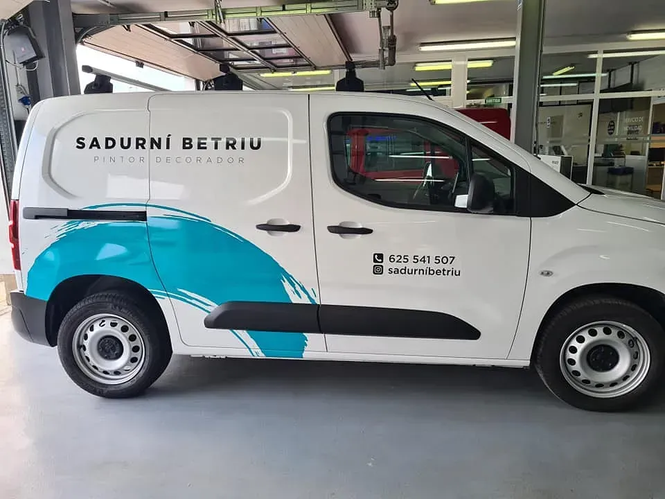 Furgoneta blanca con diseño de olas en color verde azulado, publicidad "SADURNI BETRIU, PINTOR, DECORACION" e información de contacto.