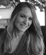 Une femme aux cheveux longs sourit sur une photo en noir et blanc.