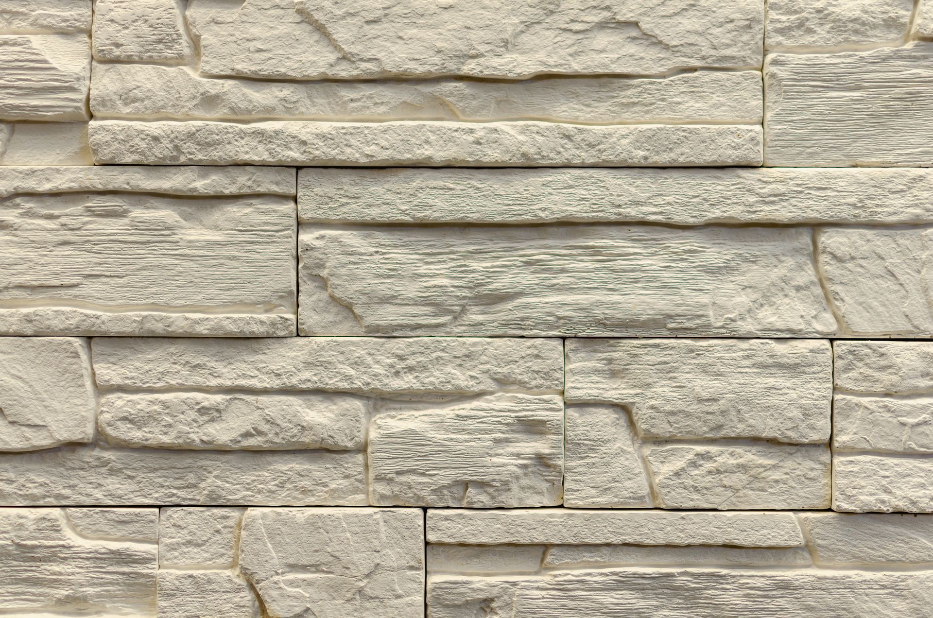 Gros plan sur un mur en briques de pierre texturées gris clair.