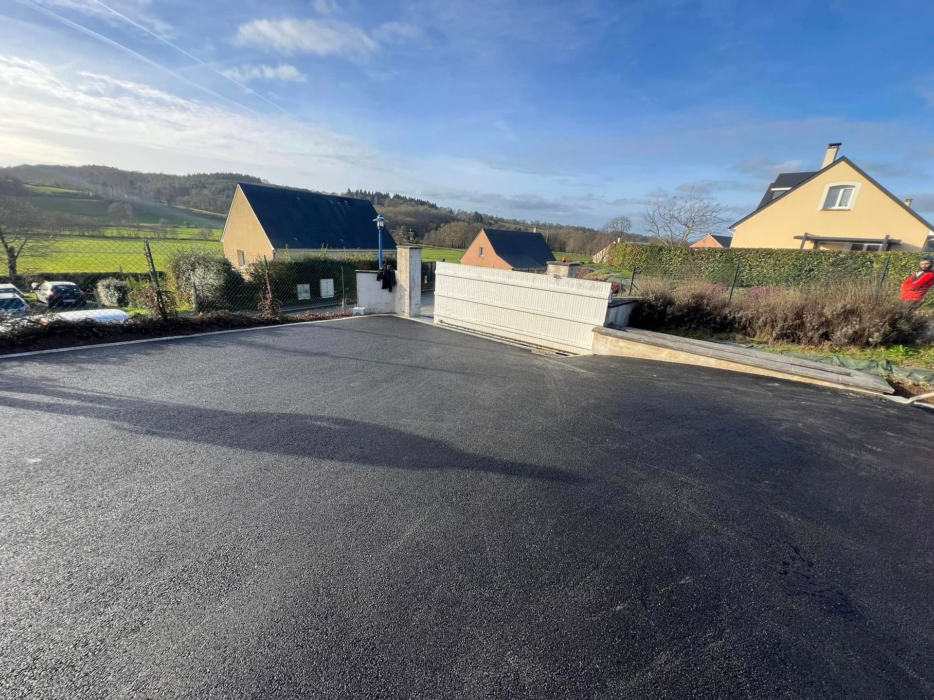 Pose d'un enrobé à chaud noir et d'une clôture en panneaux rigides avec occultants 