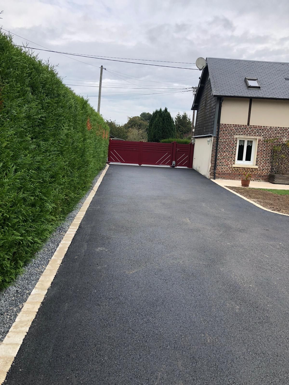 Pose d'un enrobé à chaud noir et pavés ton pierre en bordure