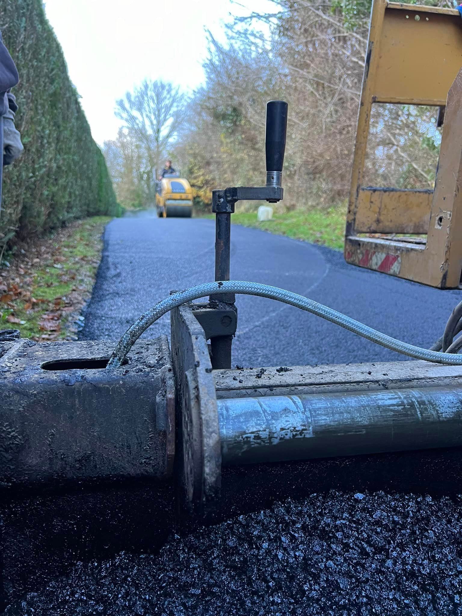 Pose d'un enrobé à chaud noir avec un finisseur