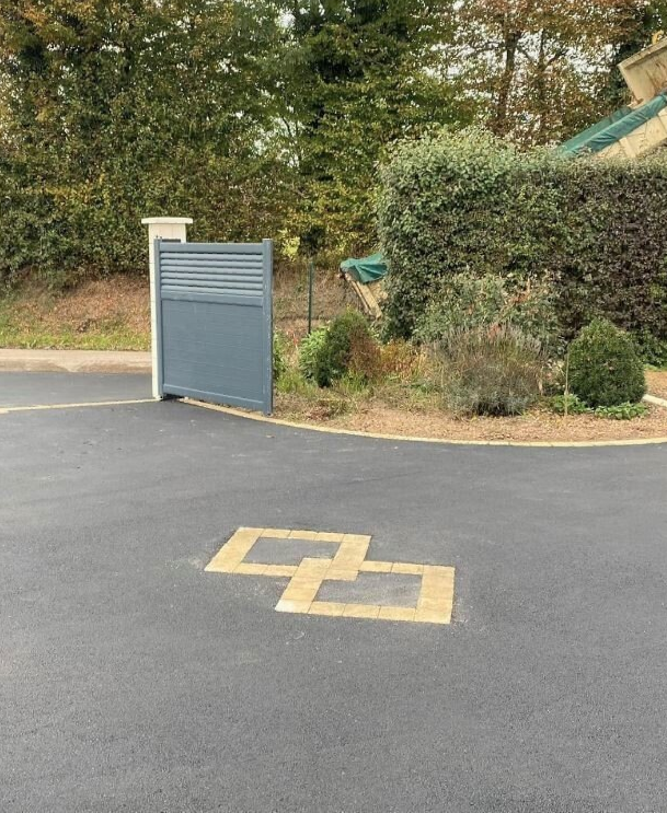 Pose d'un enrobé à chaud noir avec forme en pavés ton pierre 