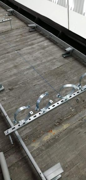 Un primer plano de una abrazadera de tubo de metal sobre un piso de madera.