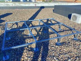 Un marco de metal está colocado encima de un techo cubierto de grava.