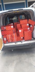 La parte trasera de una camioneta blanca está llena de cajas.