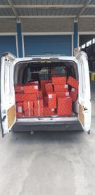 La parte trasera de una camioneta blanca está llena de cajas.