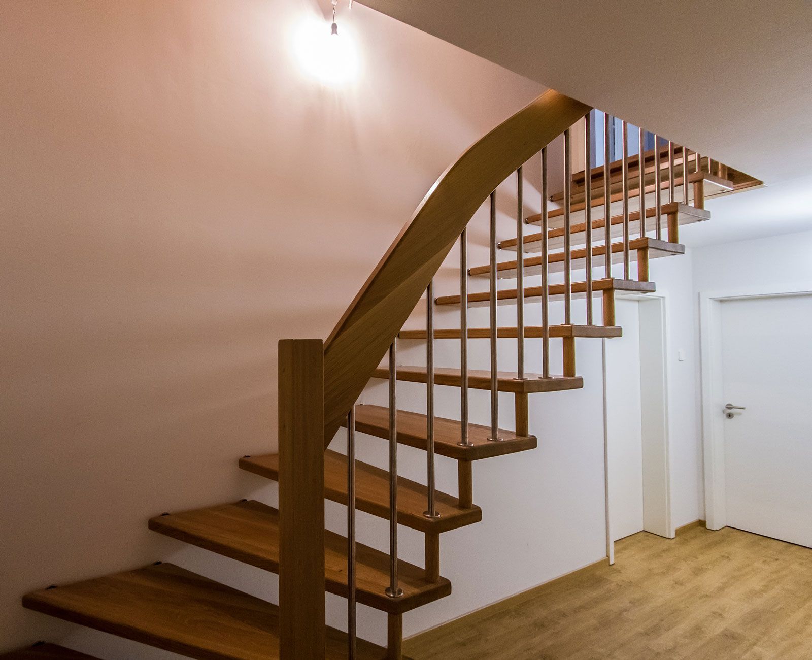 Eine Holztreppe mit einem Metallgeländer in einem Flur