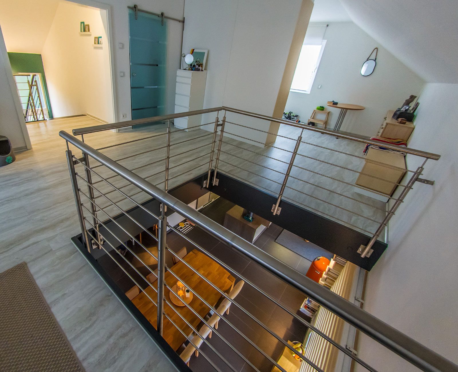 Eine Treppe mit Edelstahlgeländer, die in den zweiten Stock führt