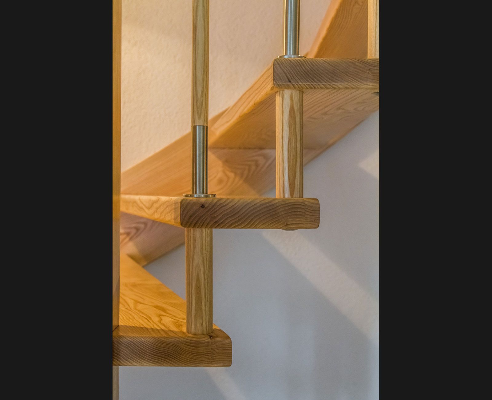 Eine Nahaufnahme einer Holztreppe mit einem Metallgeländer.