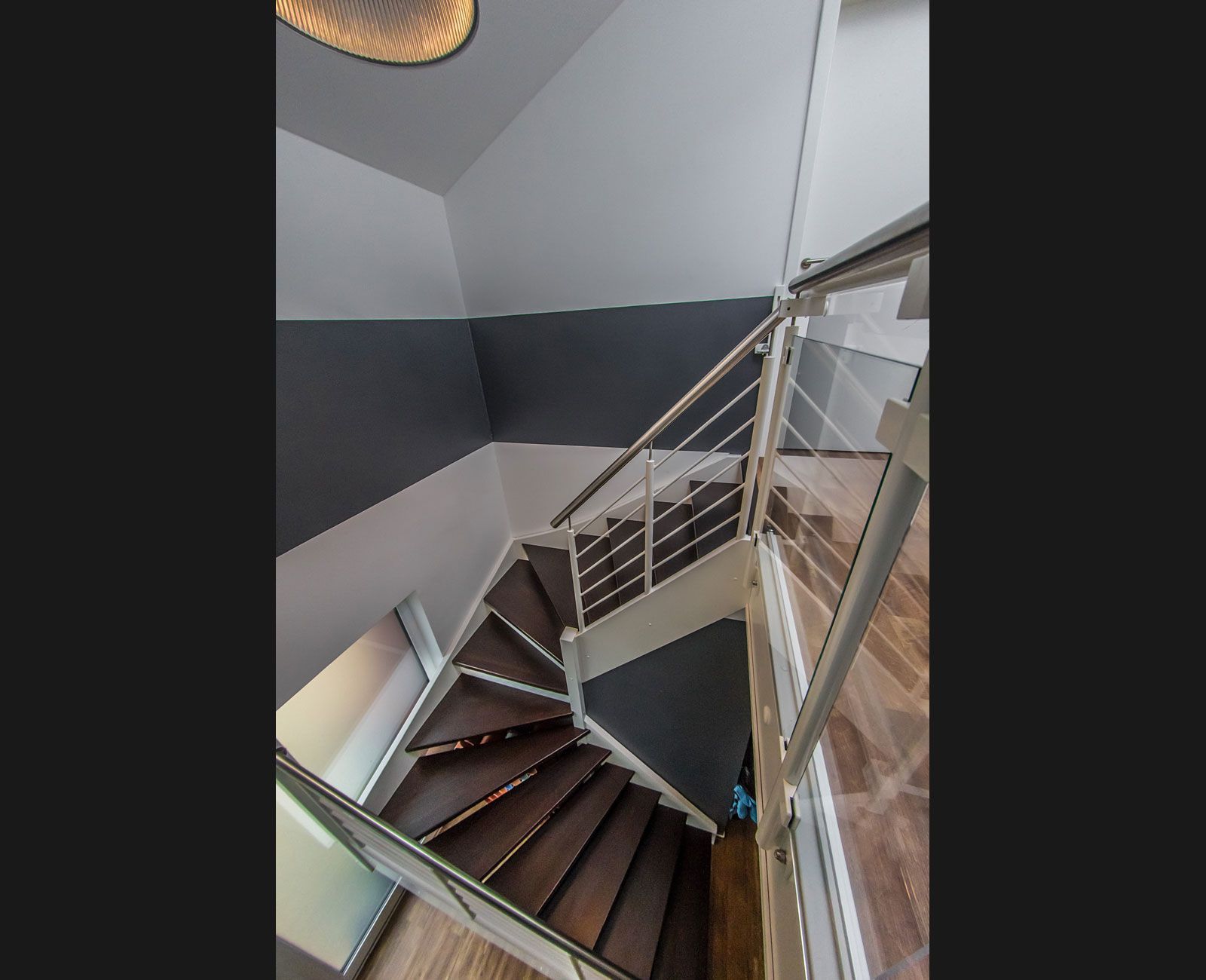 Eine Wendeltreppe mit weißem Geländer und Holzstufen