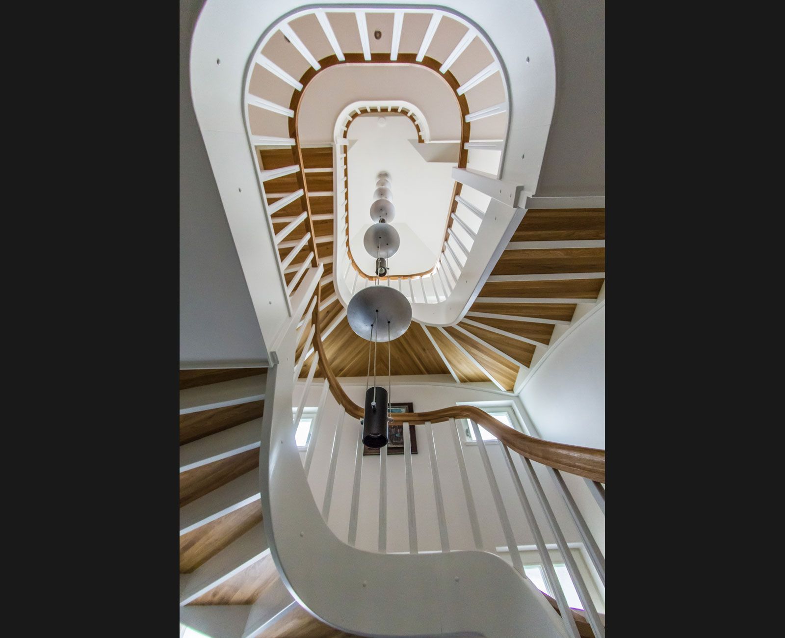 Eine Wendeltreppe mit Holzstufen und einem weißen Geländer