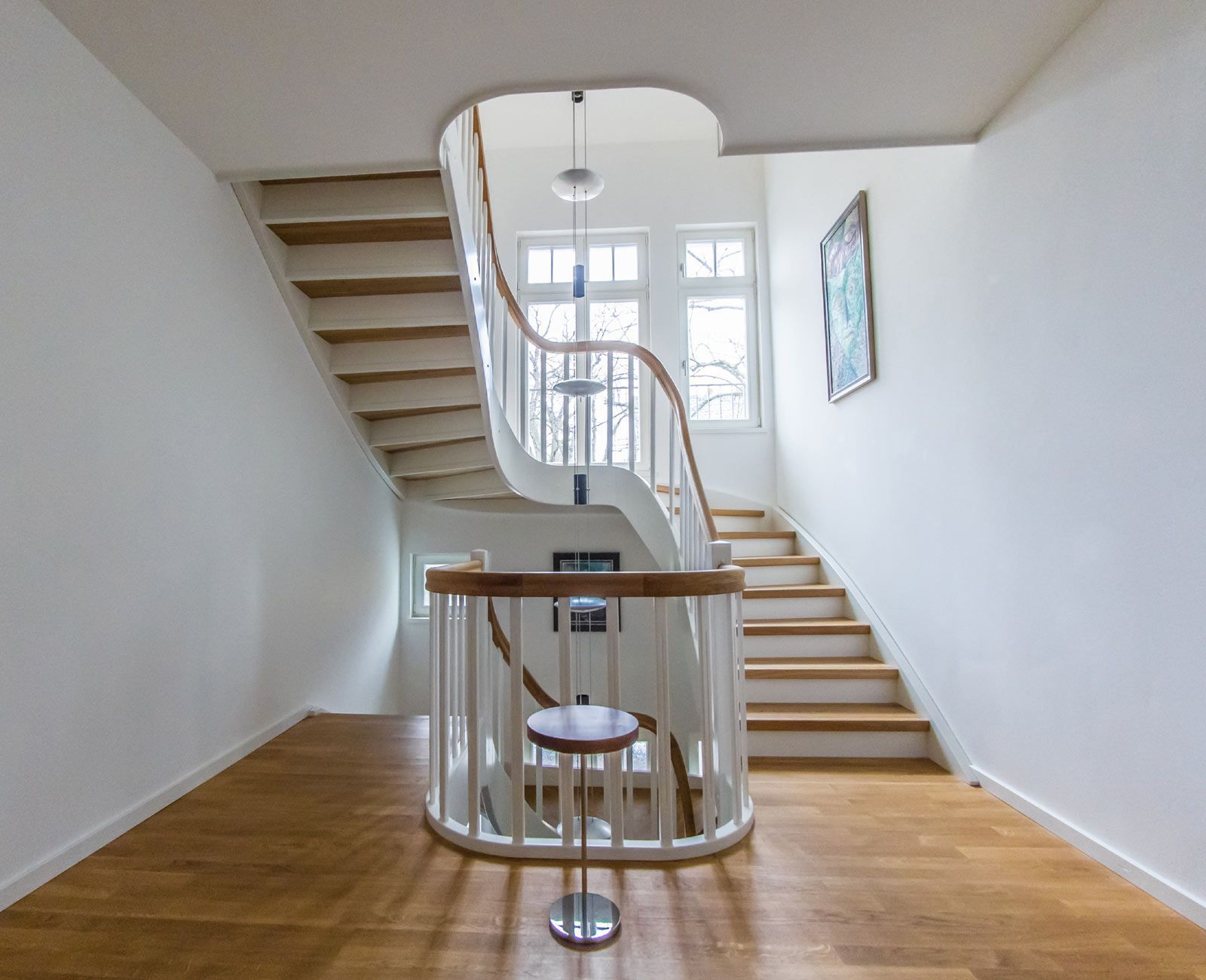 Eine weiße Treppe mit Holzstufen und einem Holzgeländer