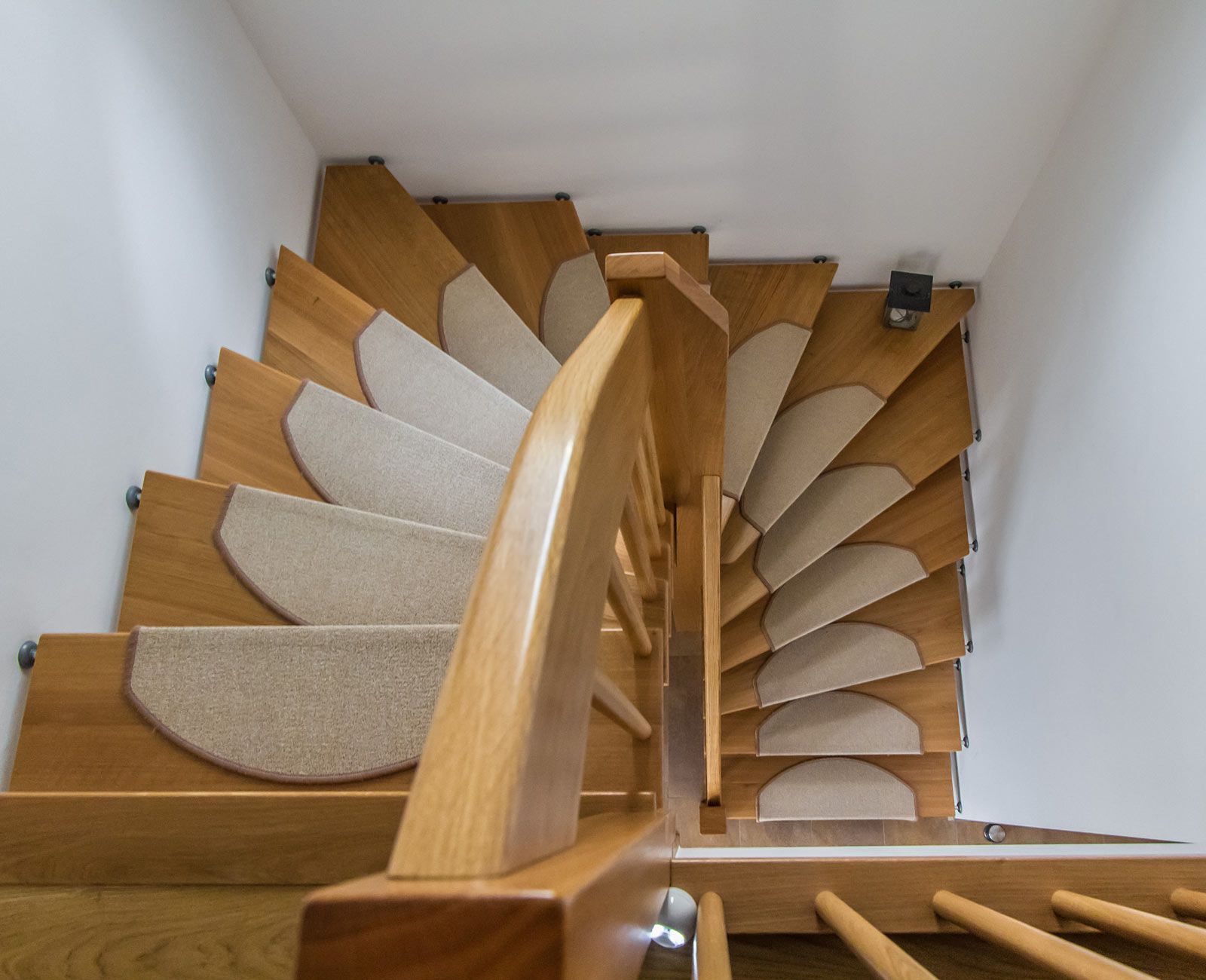 Eine Wendeltreppe mit Teppichstufen und Holzgeländer