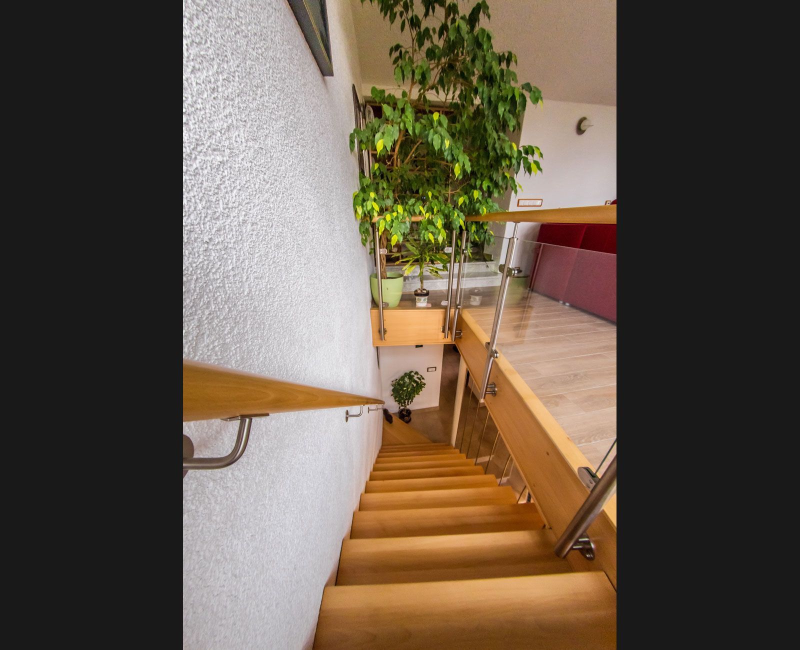 Eine Holztreppe, die in den zweiten Stock eines Hauses führt.