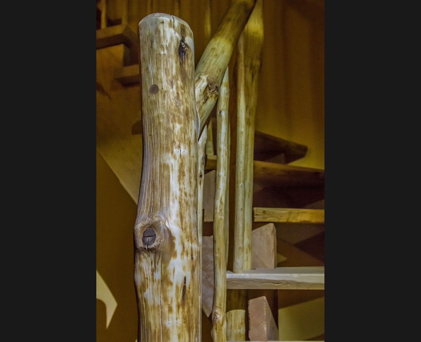 Eine Holztreppe mit einem Holzgeländer aus Baumstämmen.