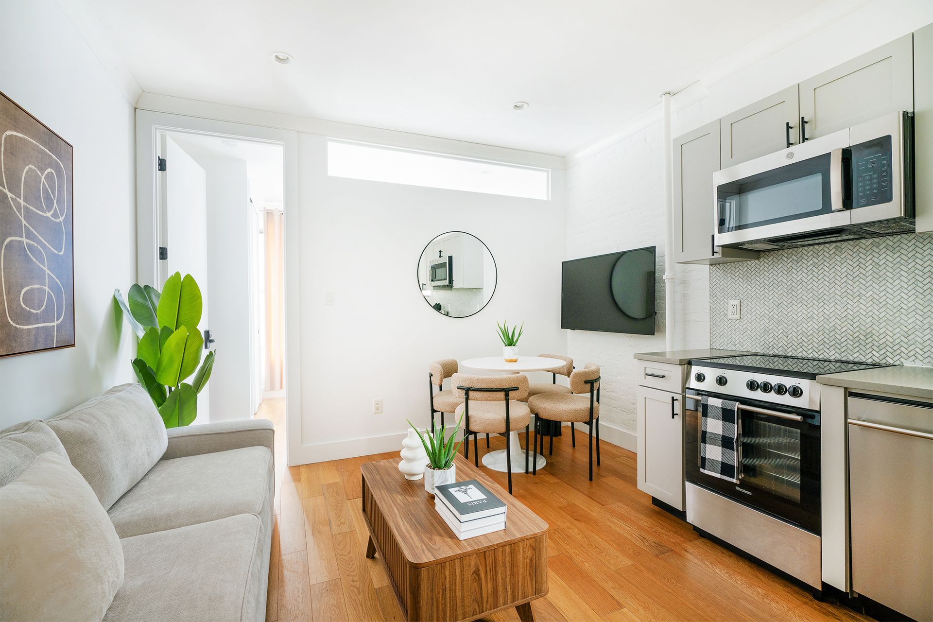Two-bedroom apartment with a dining table,  kitchen appliances, and wall-mounted TV. The apartment is in the Upper East Side.