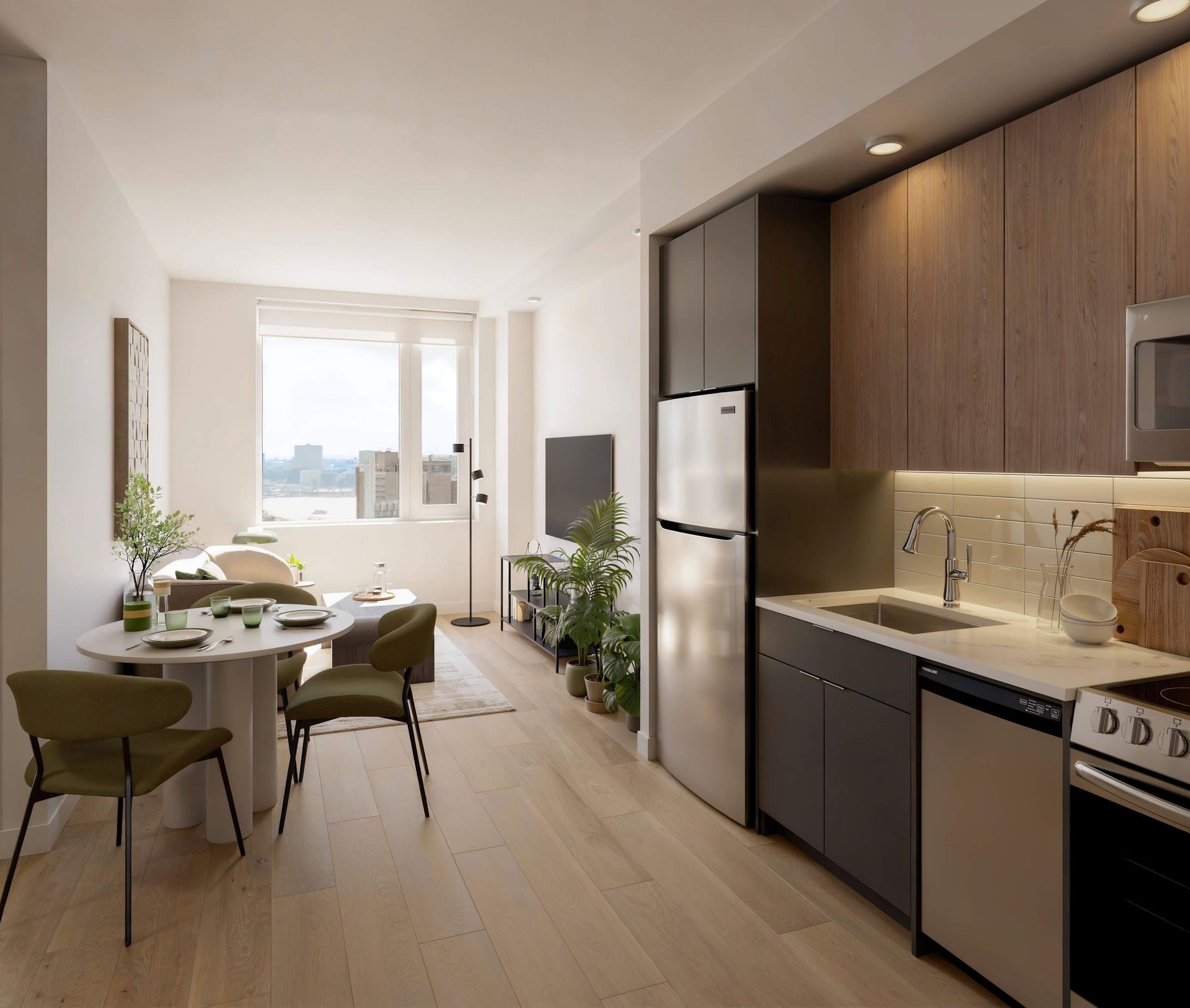 Modern one-bedroom apartment with a gray sofa, round wooden coffee table, potted plant, wall-mounted TV, and large round wall mirror. The apartment includes a doorman and gym and is located in the Upper West Side.